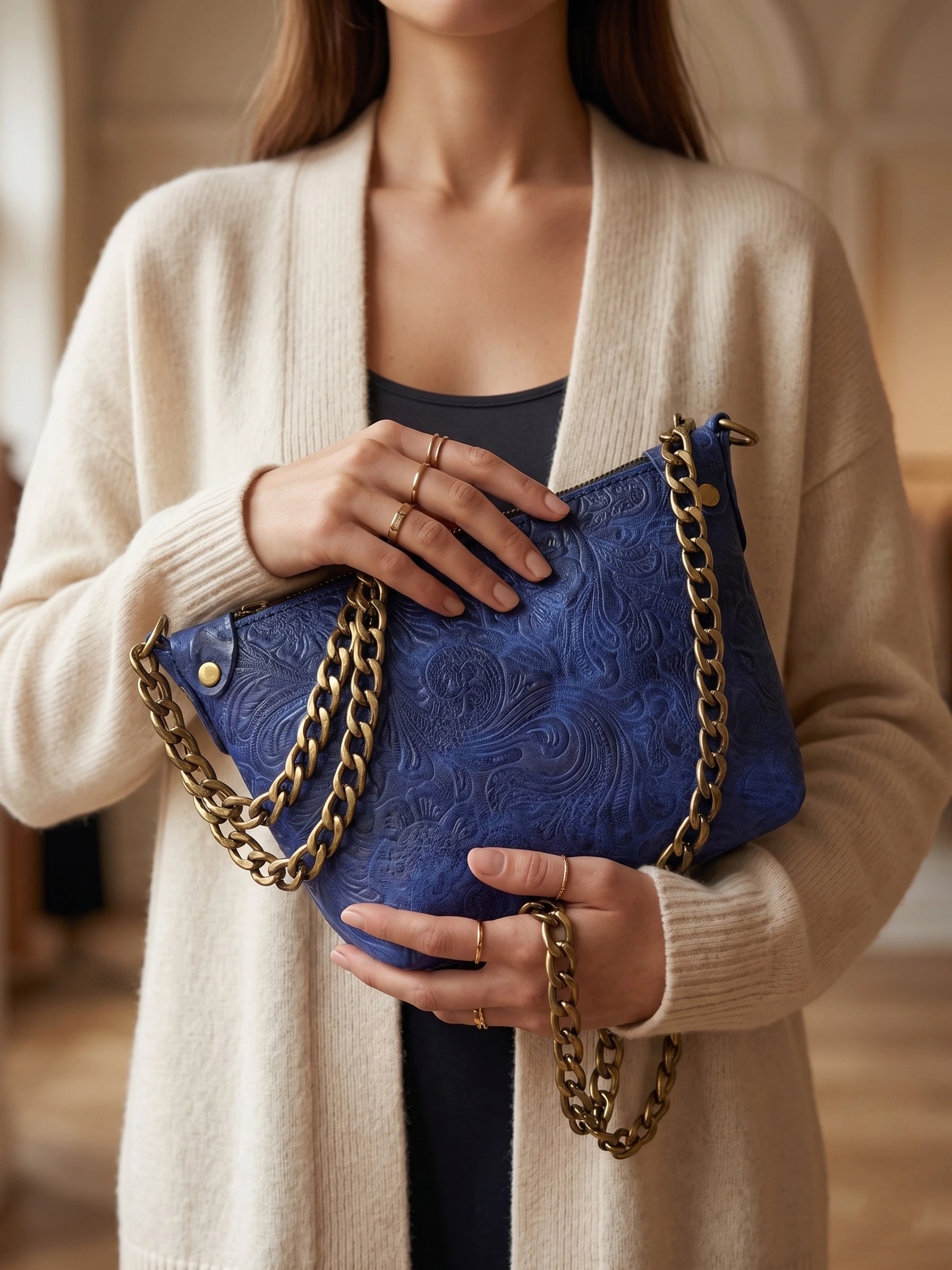 Kadının elinde kabartma desenli mavi Vudi Leather deri omuz çantası